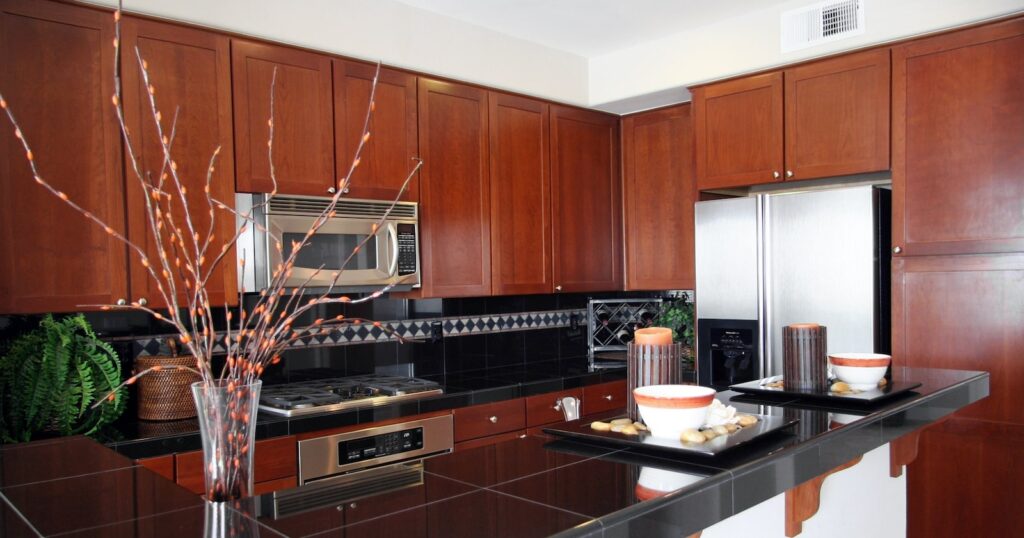 Walnut cabinet and black counter kitchen design.