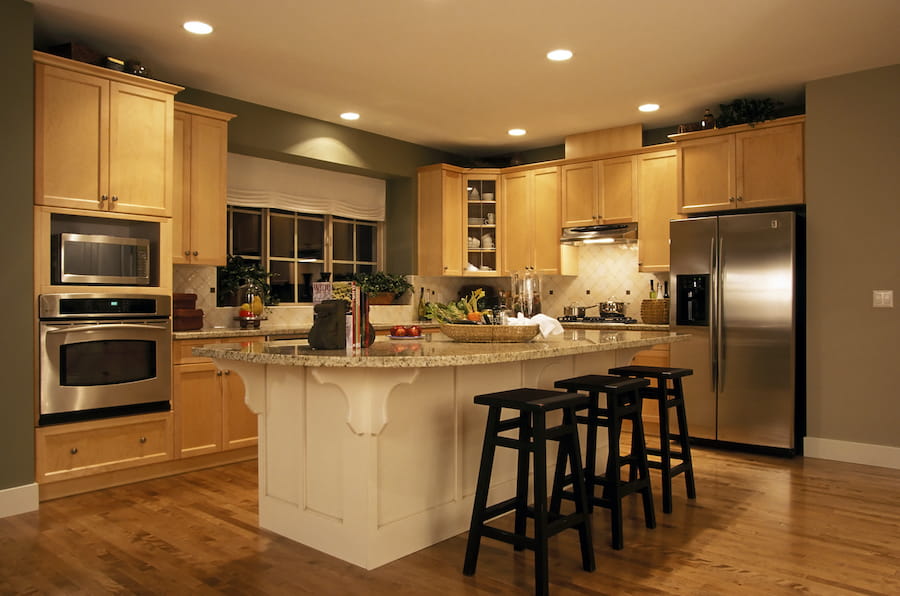 Contemporary kitchen with light wood cabinets and lighting