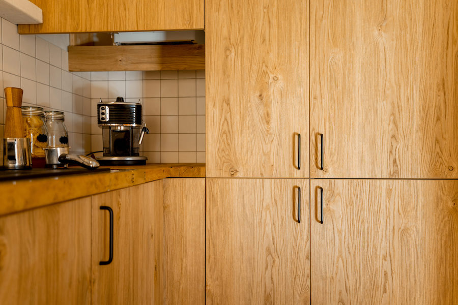 - Light wood cabinetry with under-cabinet lighting and modern hardware